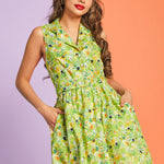 Woman modeling sleeveless hidden kitty print dress in lush green botanical pattern