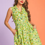 Woman modeling sleeveless hidden kitty print dress in lush green botanical pattern