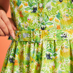 Close-up of hidden cat novelty print on green botanical cotton dress with matching belt detail