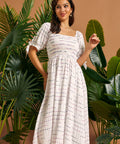 Front view of a white textured midi dress with a smocked bodice, square neckline, and gathered skirt.