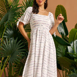 Front view of a white textured midi dress with a smocked bodice, square neckline, and gathered skirt.