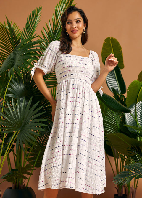 Front view of a white textured midi dress with a smocked bodice, square neckline, and gathered skirt.