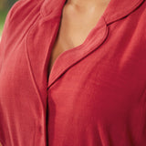 Close-up detail view of a woman wearing a vintage red button bodice dress with a relaxed collar and soft draped fabric.