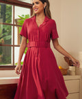 A woman modeling a short-sleeve midi dress in a solid red color.
