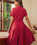 Back view of a woman wearing a short-sleeve, collared A-line red dress.