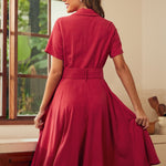 Back view of a woman wearing a short-sleeve, collared A-line red dress.