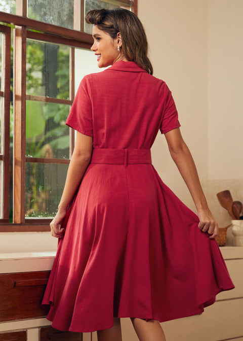Back view of a woman wearing a short-sleeve, collared A-line red dress.