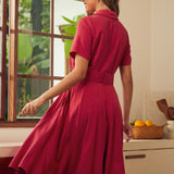 Back view of a woman wearing a short-sleeve, collared, knee-length red vintage inspired dress.