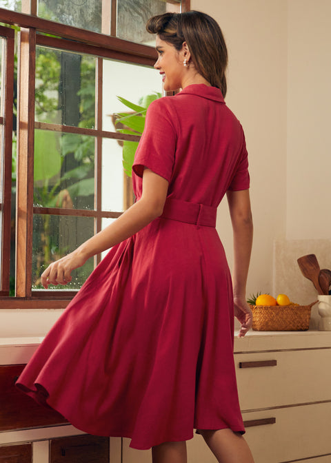 Back view of a woman wearing a short-sleeve, collared, knee-length red vintage inspired dress.