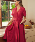 A woman wearing a short-sleeve, collared midi dress in red.