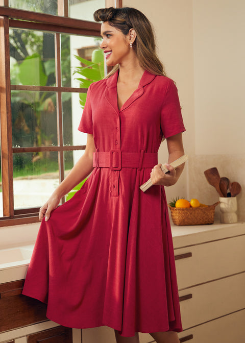A woman wearing a short-sleeve, collared midi dress in red.