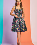 Woman wearing navy retro mini dress with colorful polka dot print and sweetheart neckline