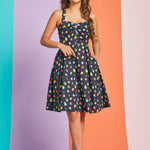 Woman wearing navy retro mini dress with colorful polka dot print and sweetheart neckline