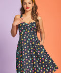 Woman wearing vintage-inspired polka dot mini dress with gathered bust detail and pockets