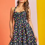 Woman wearing a polka dot party dress with a colorful background
