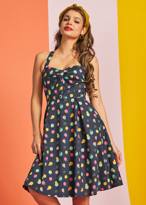 Woman wearing a polka dot party dress with a colorful background