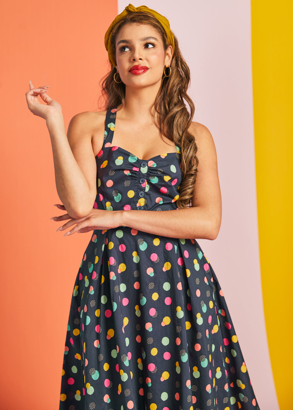 Woman wearing navy polka dot party dress with fit-and-flare silhouette