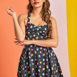 Woman wearing navy polka dot party dress with fit-and-flare silhouette