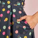 Close-up of colorful polka dot print and functional side pocket on navy cotton dress