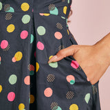 Close-up of colorful polka dot print and functional side pocket on navy cotton dress