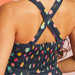 Back view of navy fit-and-flare mini dress with crisscross straps and smocked back panel