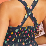 Back view of navy fit-and-flare mini dress with crisscross straps and smocked back panel