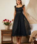 Black tulle fit and flare dress with polka dot mesh overlay and flutter straps, front view