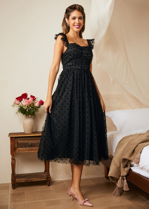 Side angle of black fit and flare dress with flutter straps and layered tulle skirt