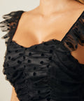 Close-up of ruched bodice with sheer polka dot mesh overlay and flutter straps