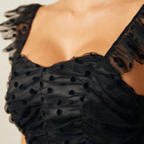 Close-up of ruched bodice with sheer polka dot mesh overlay and flutter straps