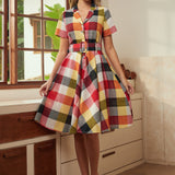 Woman wearing a vintage-inspired wine plaid dress with a full twirl-ready skirt.