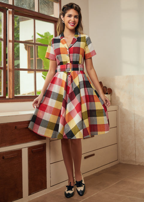 Woman wearing a vintage-inspired wine plaid dress with a full twirl-ready skirt.