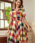 Woman wearing a retro wine plaid fit-and-flare dress with a flattering belted waist.