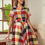 Woman wearing a retro fit-and-flare plaid dress with a notched collar and button-front bodice.