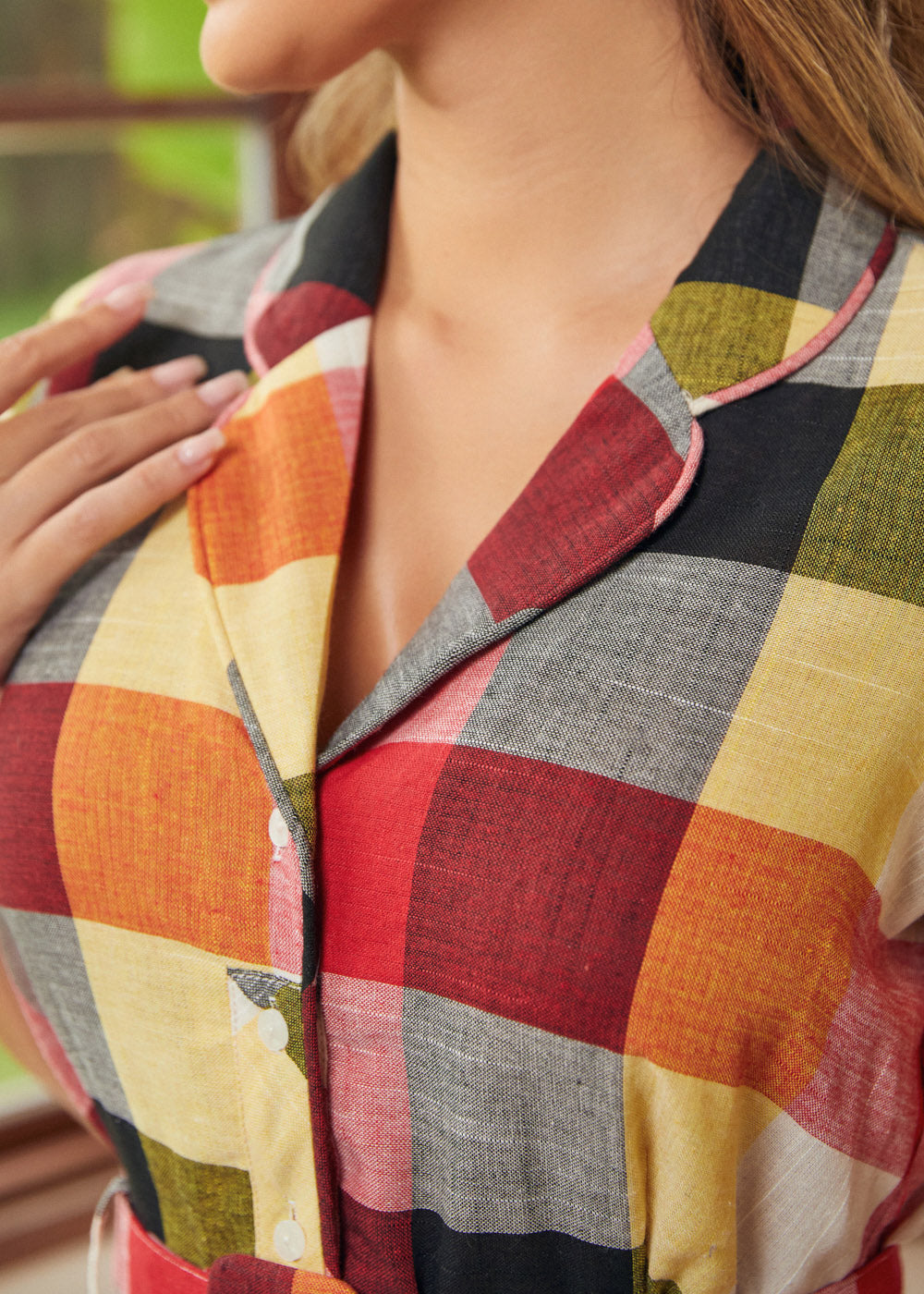 Close-up of the notched collar and button-front bodice on the wine plaid dress.