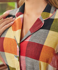 Close-up of the notched collar and button-front bodice on the wine plaid dress.