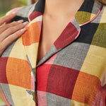 Close-up of the notched collar and button-front bodice on the wine plaid dress.