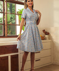 Woman wearing a vintage-inspired cherry print plaid dress with a full skirt.