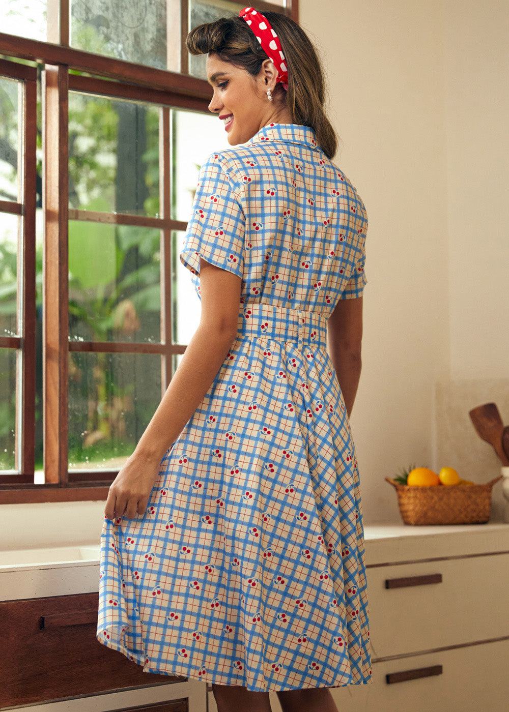 Rear view of a cherry plaid shirt dress with a full gathered skirt.