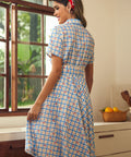 Rear view of a cherry plaid shirt dress with a full gathered skirt.