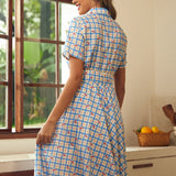 Rear view of a cherry plaid shirt dress with a full gathered skirt.