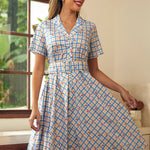 Woman wearing a blue cherry plaid fit-and-flare shirt dress with a removable belt.