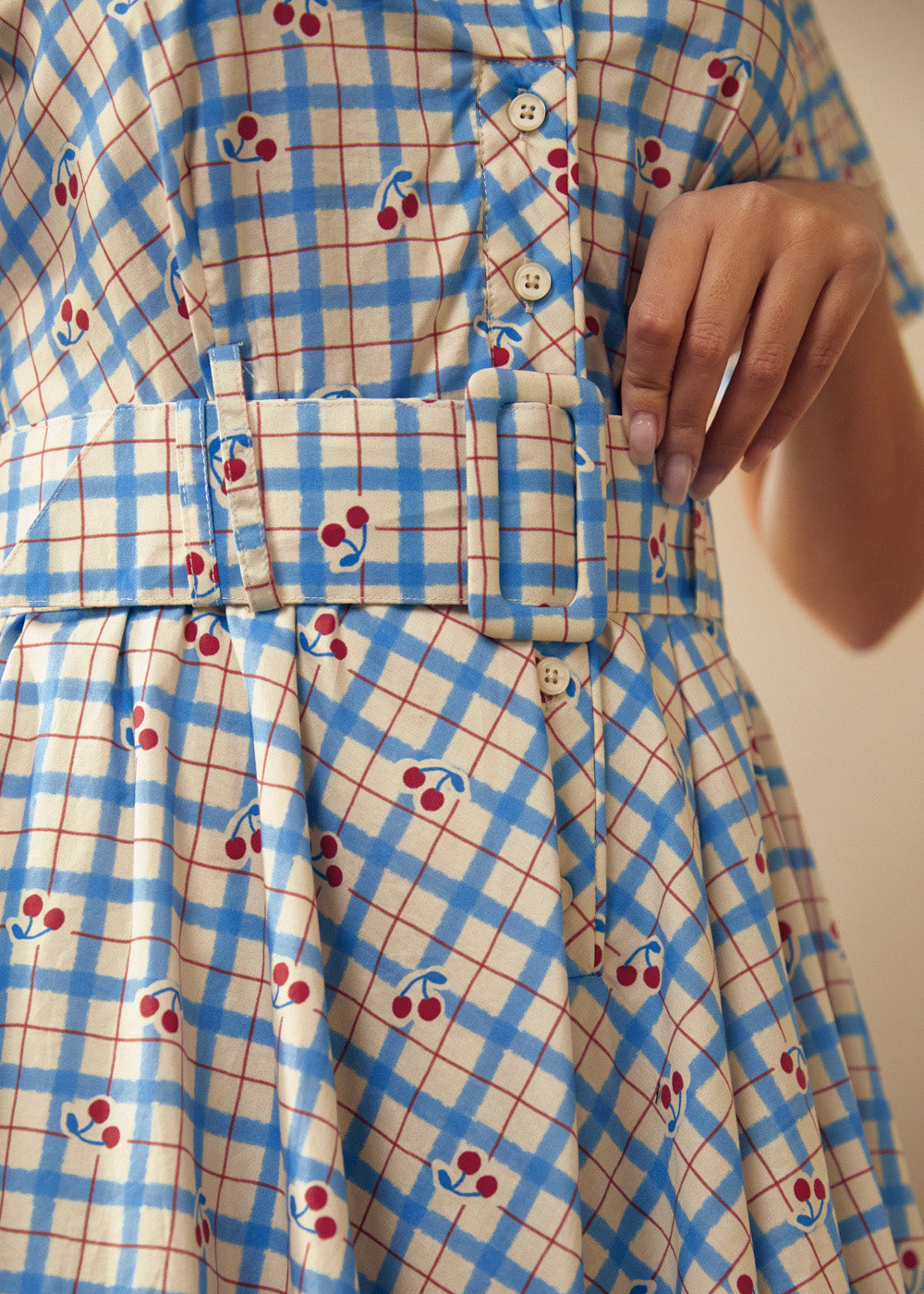 Close-up of the removable belt and cherry plaid print on the cotton dress.