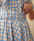 Close-up of the removable belt and cherry plaid print on the cotton dress.