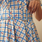 Close-up of the removable belt and cherry plaid print on the cotton dress.