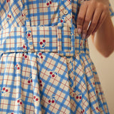 Close-up of the removable belt and cherry plaid print on the cotton dress.