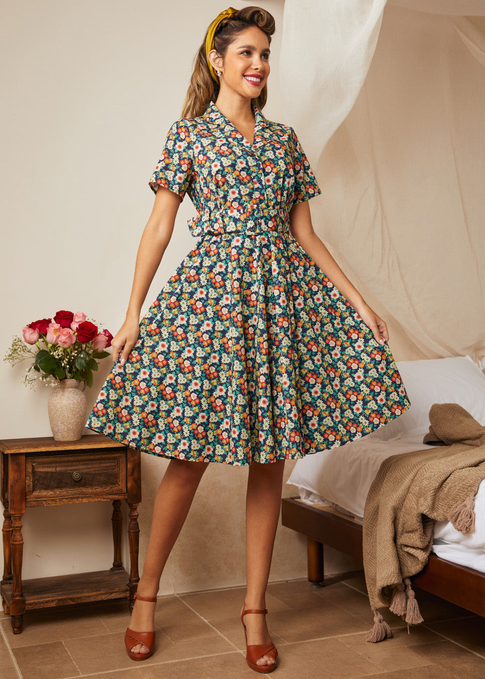 Woman wearing a navy floral fit-and-flare shirt dress with a removable matching belt.