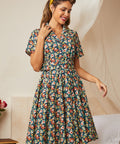 Woman wearing a vintage floral shirt dress with short sleeves and a gathered skirt.