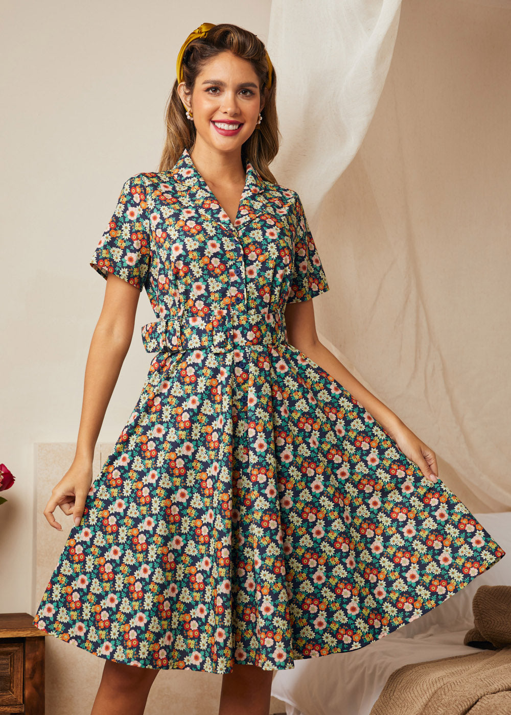 Woman wearing a vintage-inspired midnight floral belted fit-and-flare dress.