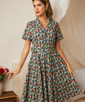 Woman wearing a retro-inspired navy floral cotton dress with a full skirt.